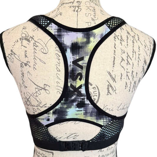 Sports bra with 'VSX' branding on a mannequin with a script background
