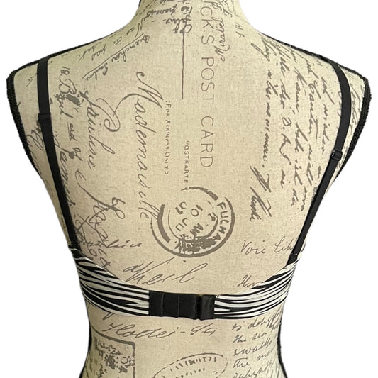 Back of a black and white bra on a mannequin on a white background.