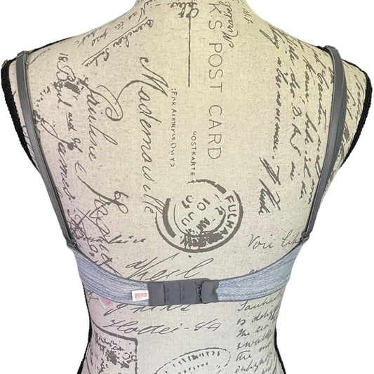 Back view of a mannequin wearing a vest with vintage letter and postcard design.