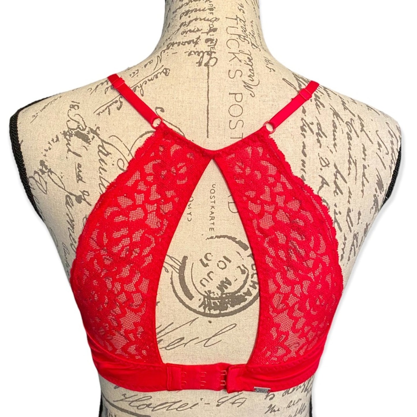 Red lace bra displayed on a vintage-style fabric mannequin torso against a white background.