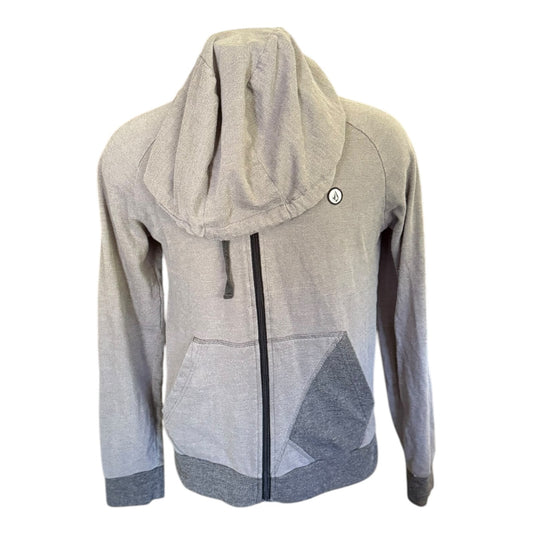 A heather gray zip-up hoodie with a large draped hood, featuring a black front zipper, a drawstring, a front pocket, and color-blocked gray panels on the lower front and cuffs.