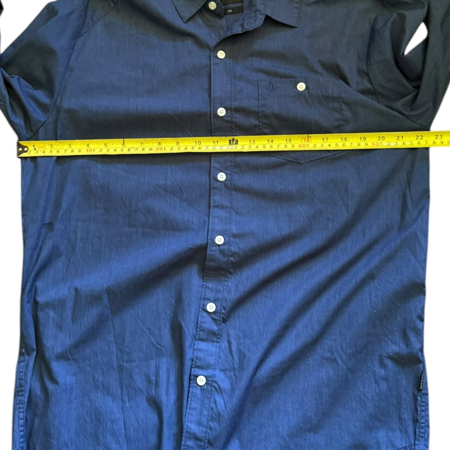Blue shirt with a measuring tape laid across it on a white background