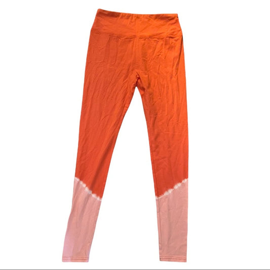 Orange leggings with a gradient to pink at the bottom on a white background