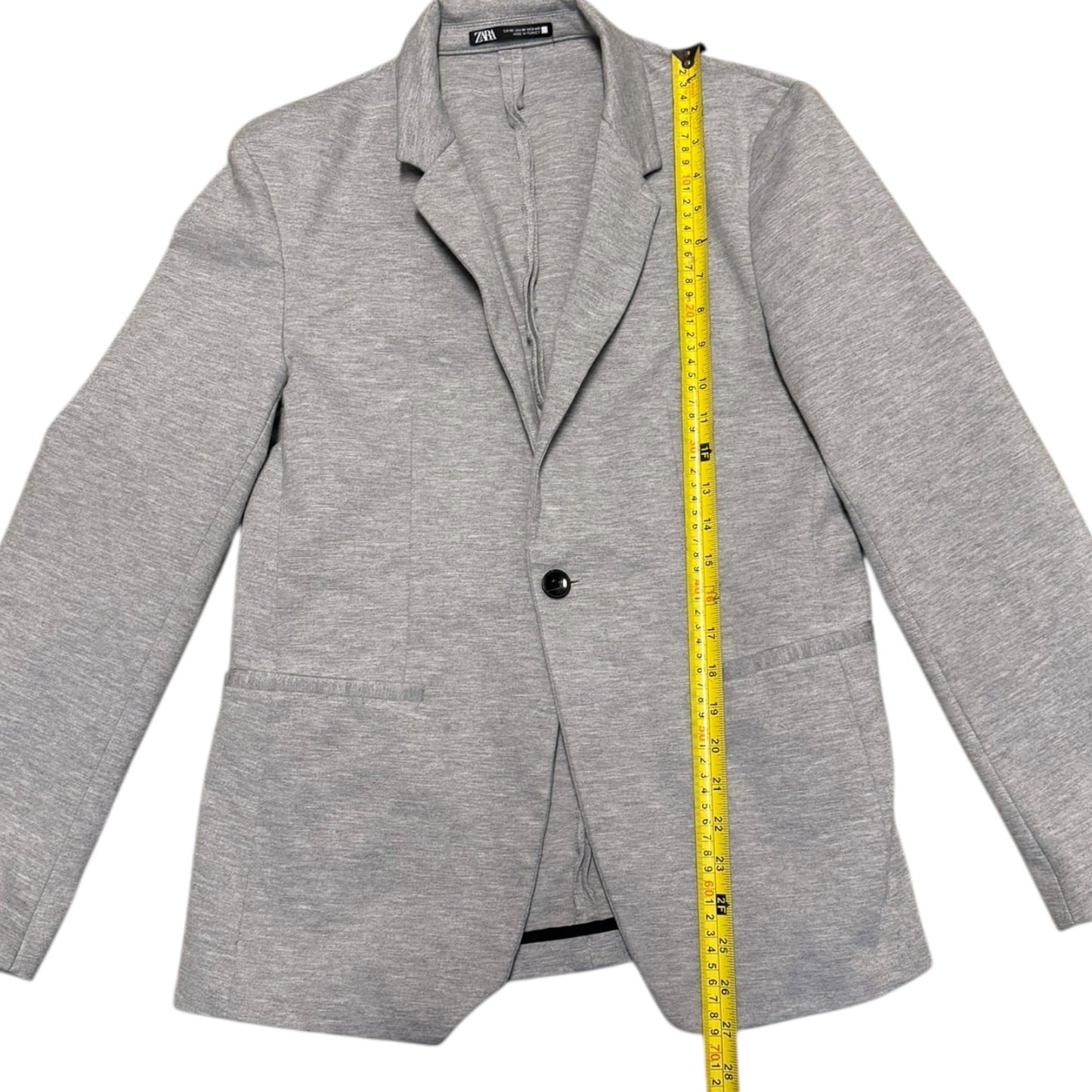 Gray blazer with a measuring tape on a white background