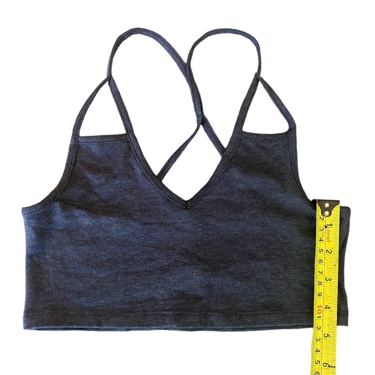 A gray top with a crossover back design, shown flat on a white background with a yellow measuring tape on the side.