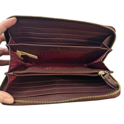 Interior wallet with gold zipper held open by a hand on a white background