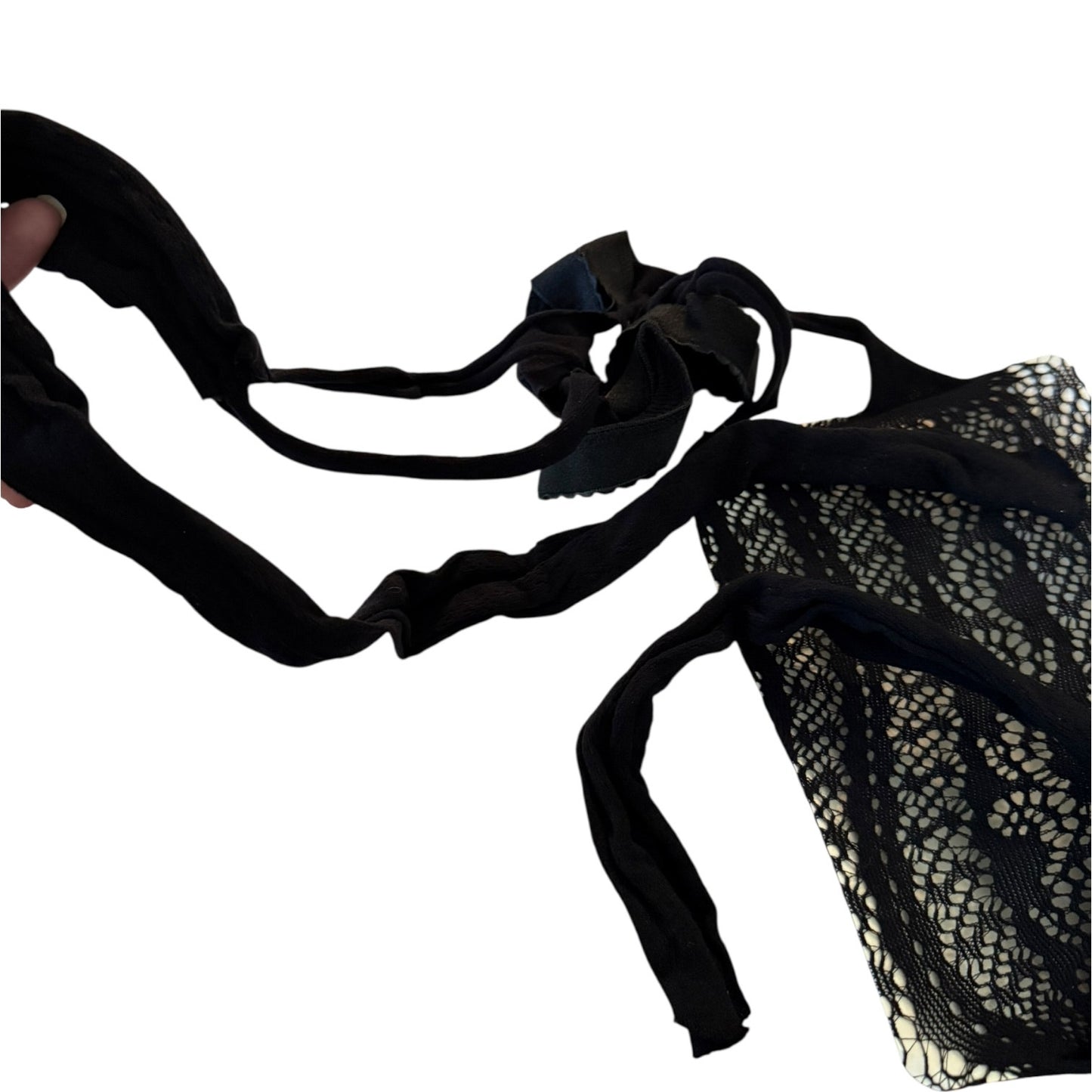 A black lace and mesh lingerie, shown against a plain white background with a hand holding one strap on the left.