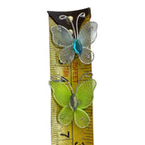 Two butterfly-shaped  on a ruler for size reference.