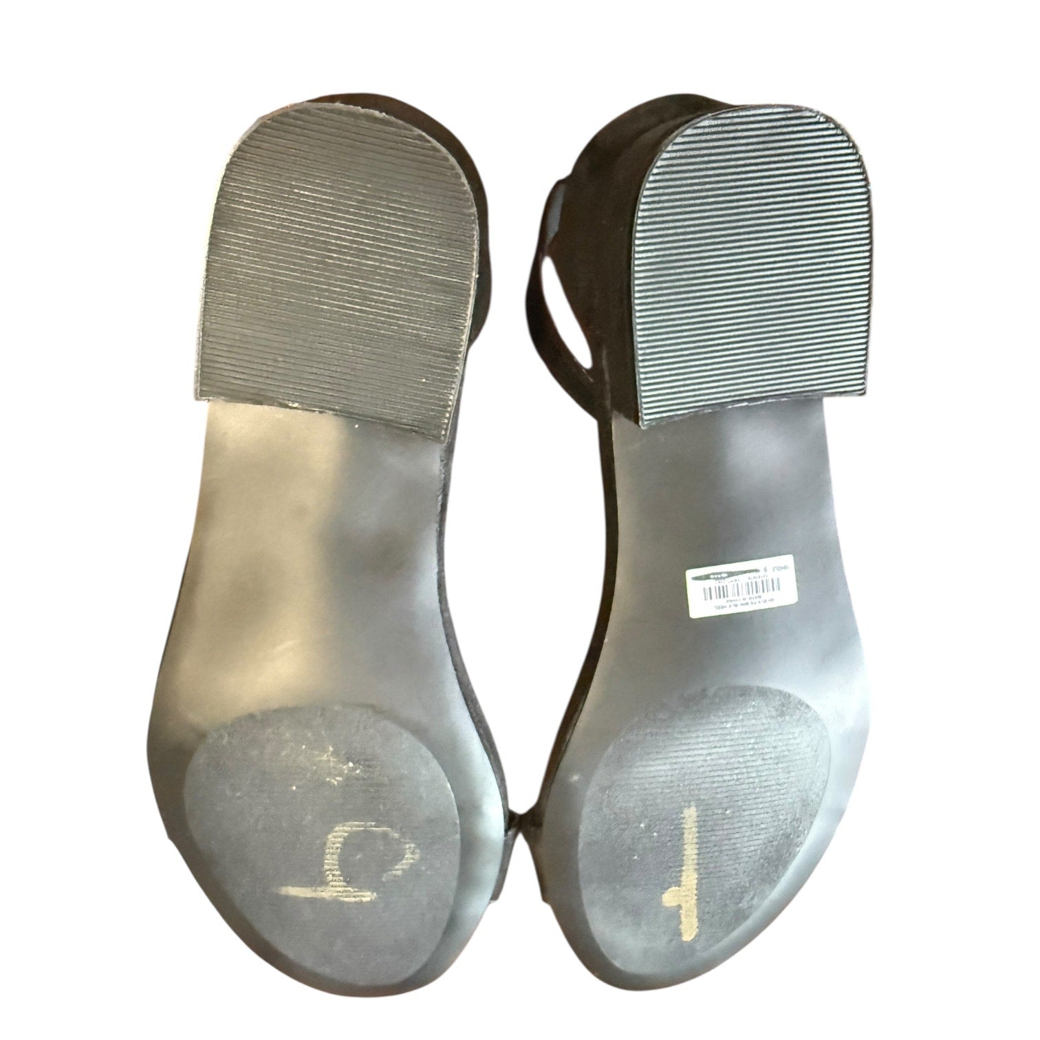 Pair of black shoes with soles facing up on a white background