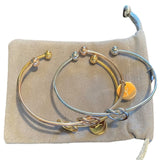 Set of silver and gold bangles on a beige fabric background