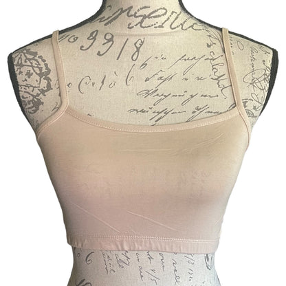 A light beige tank top displayed on a decorative dress form mannequin against a plain white background.
