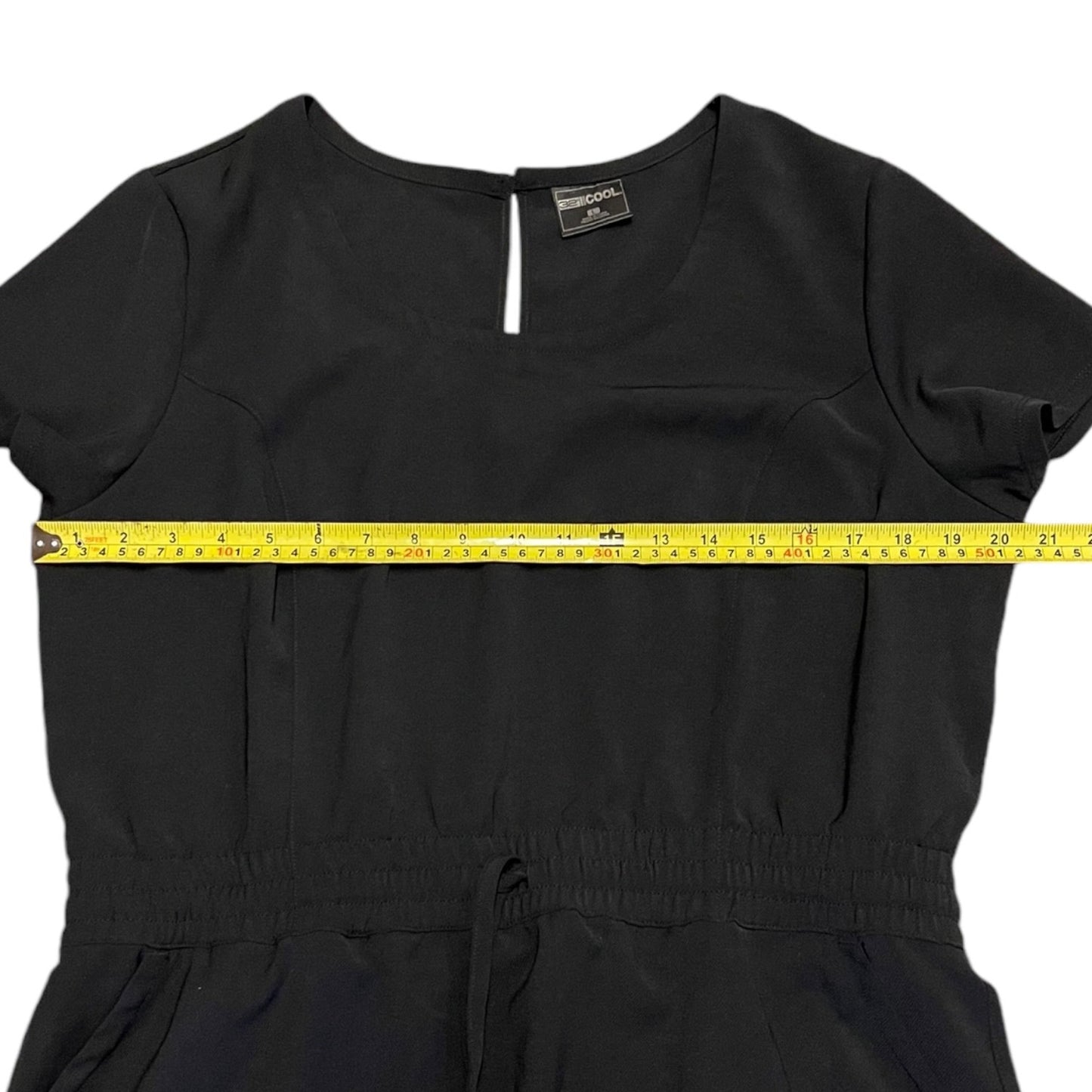 Black dress with a measuring tape around the waist on a white background