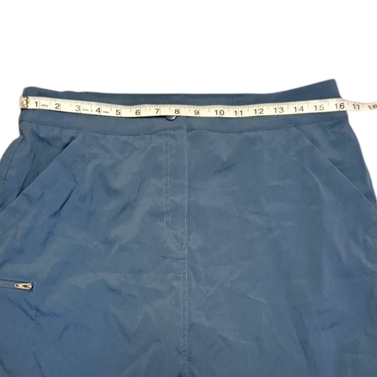 Blue skorts with a measuring tape draped over them on a white background