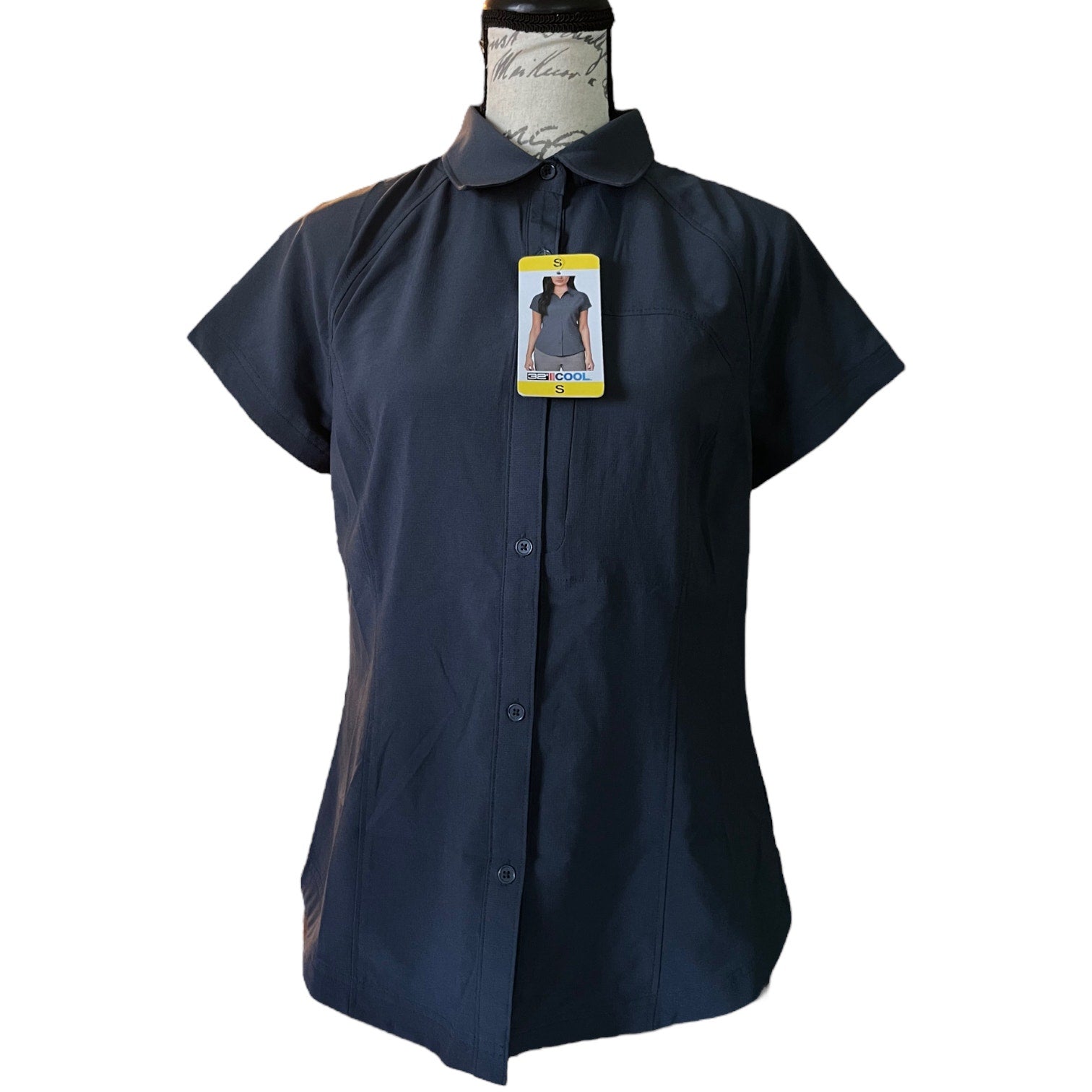 Gray shirt on a mannequin with a tag against a white background