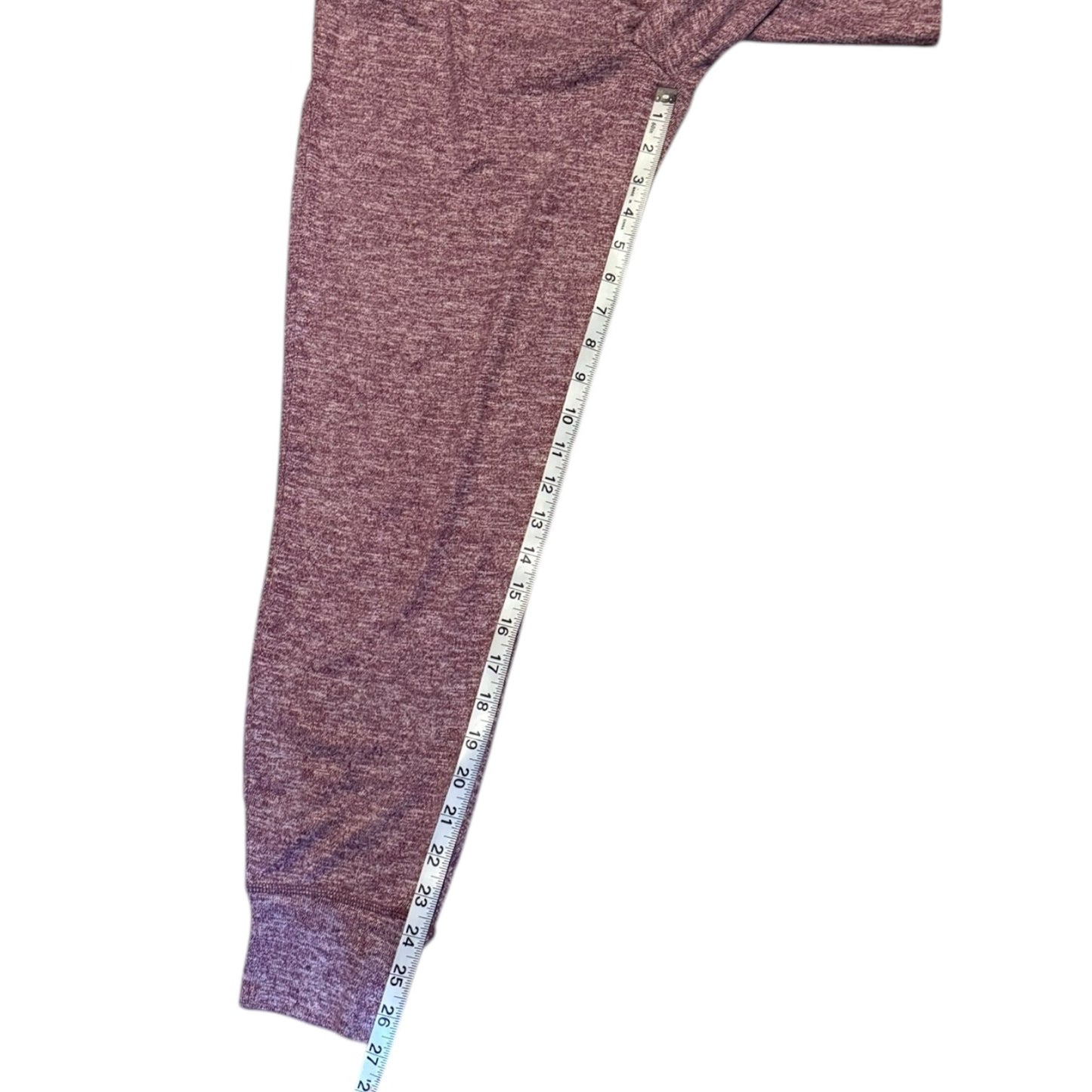 Red leggings with a measuring tape draped over them on a white background