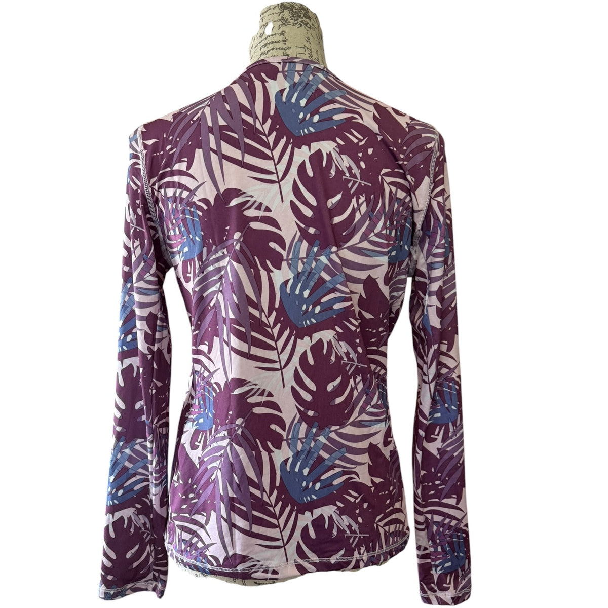 Long-sleeve shirt with a tropical leaf pattern on a mannequin against a white background