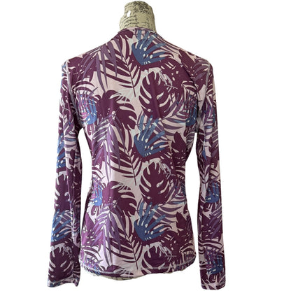 Long-sleeve shirt with a tropical leaf pattern on a mannequin against a white background