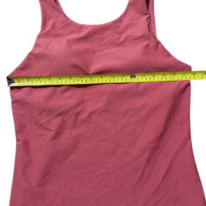 Pink tank top with a measuring tape around it on a white background