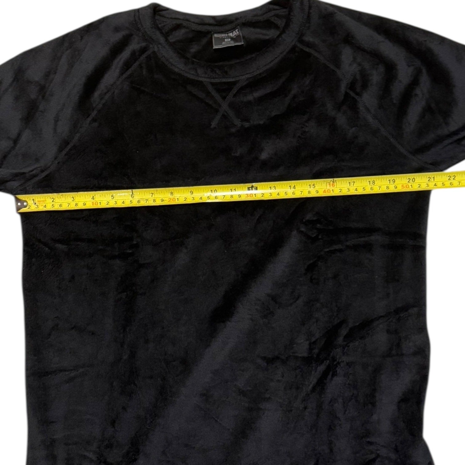 Gray shirt with a yellow measuring tape around the chest area on a white background