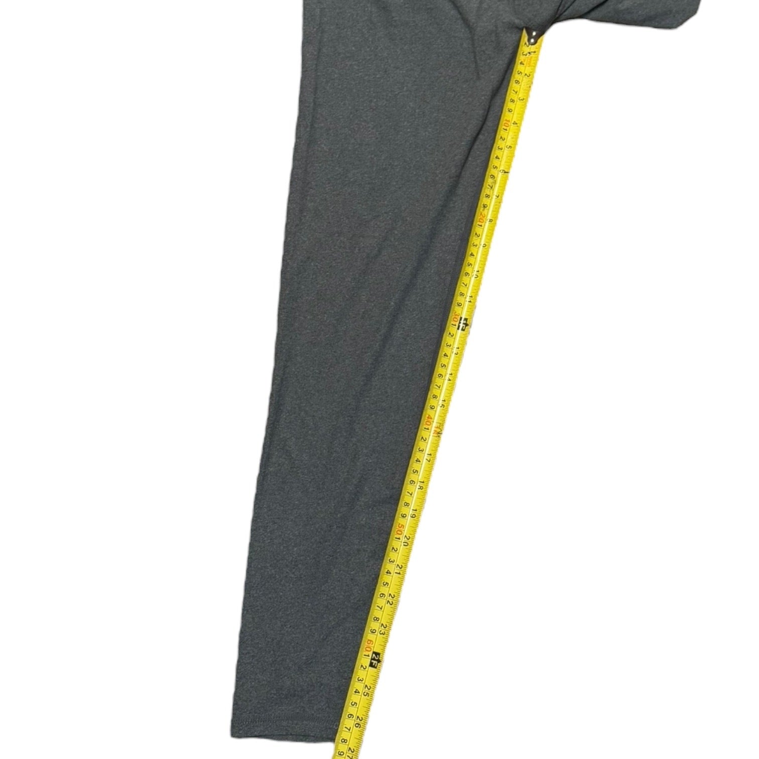 Gray leggings with a yellow measuring tape on a white background
