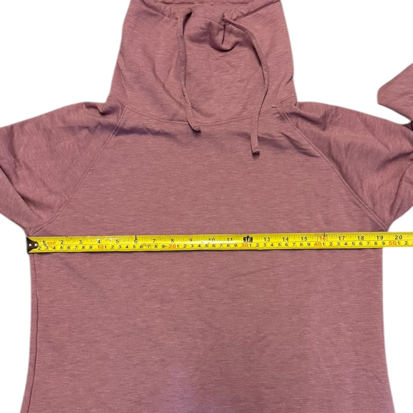 Pink sweater with a measuring tape draped over it on a white background