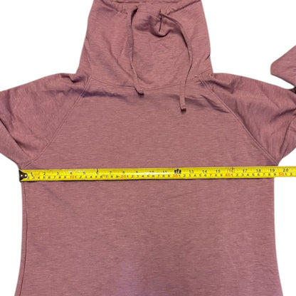 Pink sweater with a measuring tape draped over it on a white background