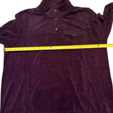Purple pullover with a yellow measuring tape across it on a white background