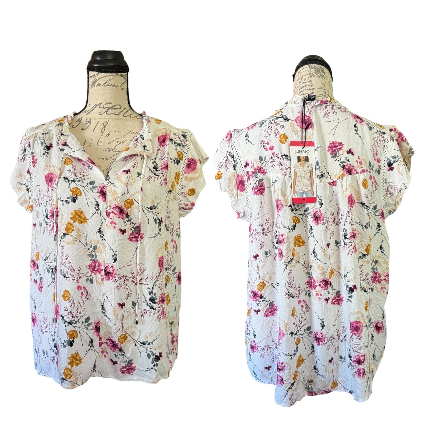 Floral blouse on a mannequin with a visible tag against a white background