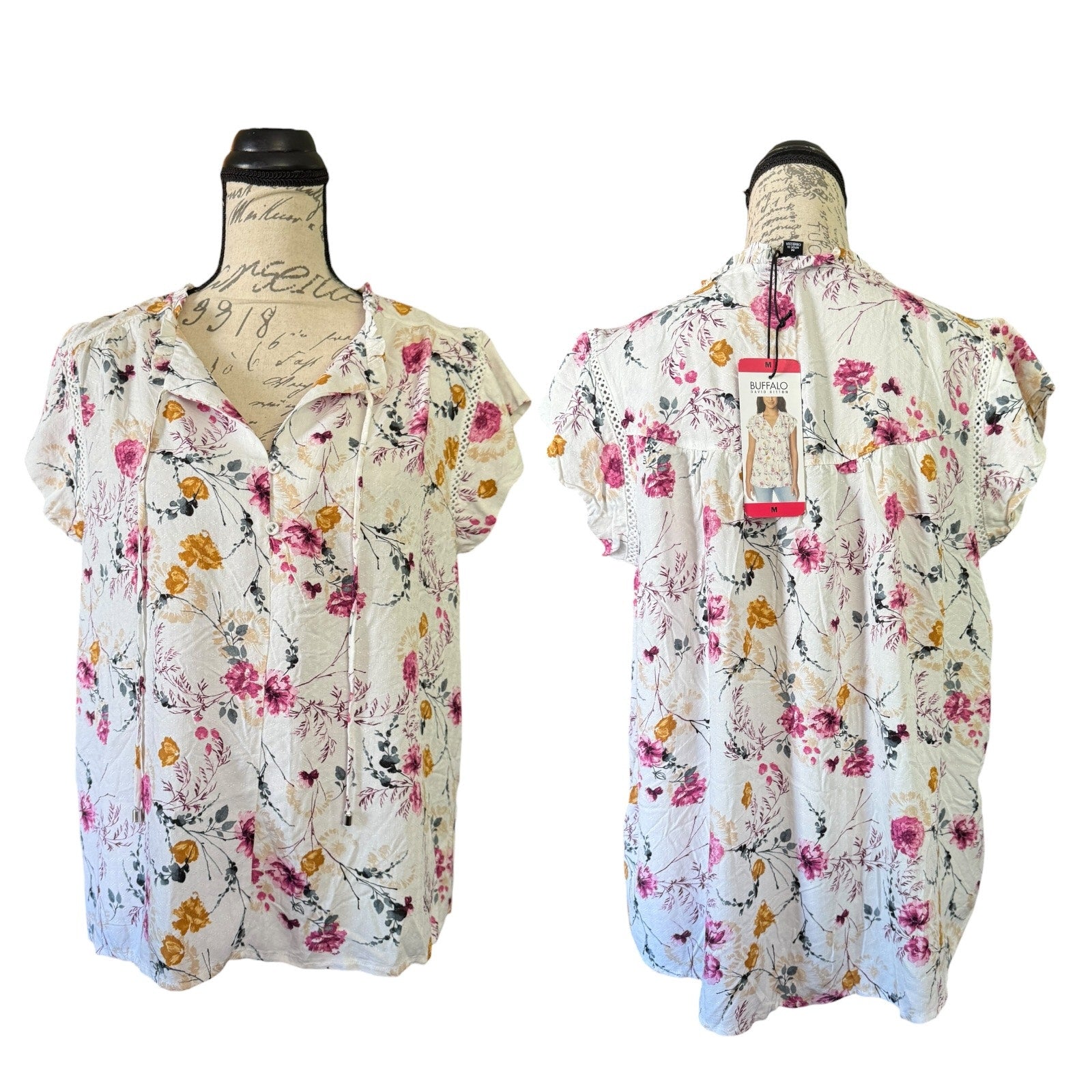 Floral blouse on a mannequin with a visible tag against a white background