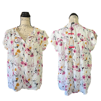 Floral blouse on a mannequin with a visible tag against a white background