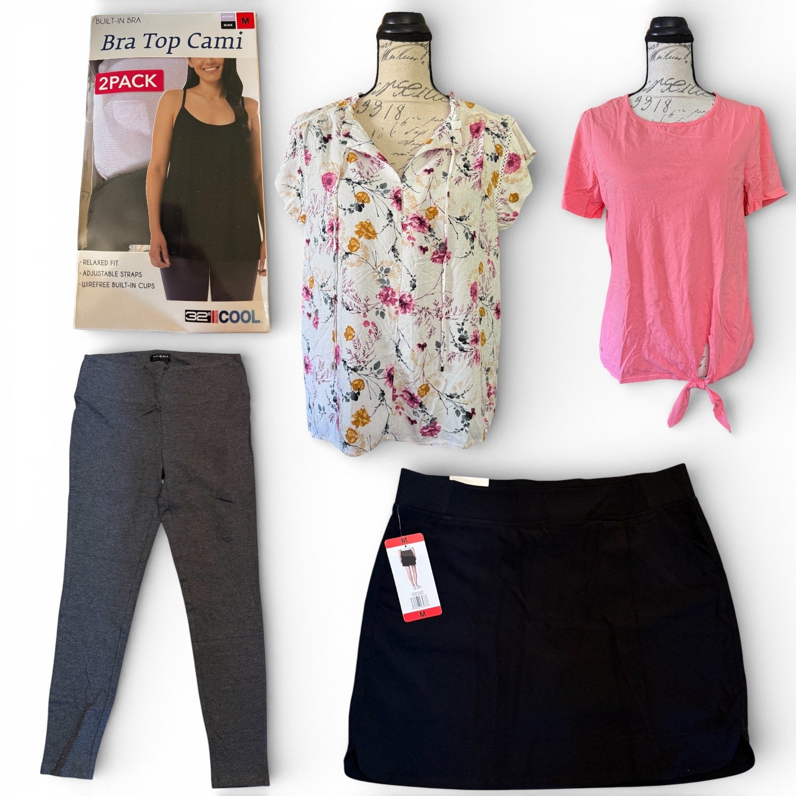 Collection of women's clothing including a floral cardigan, pink shirt, black skort, and gray pants on a white background.