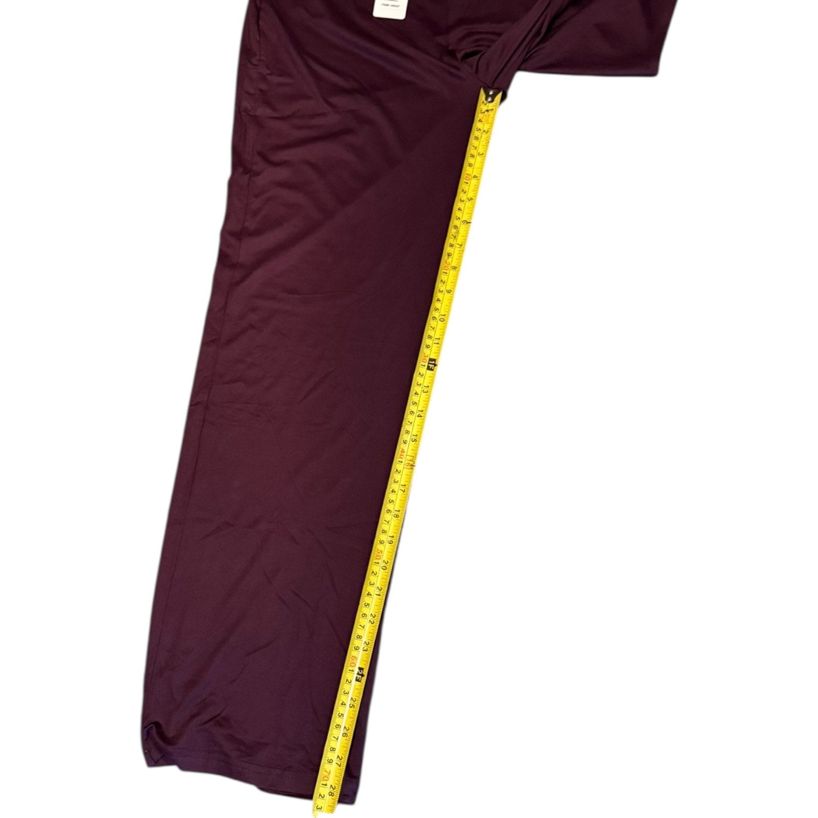 Purple pants with a yellow measuring tape on a white background