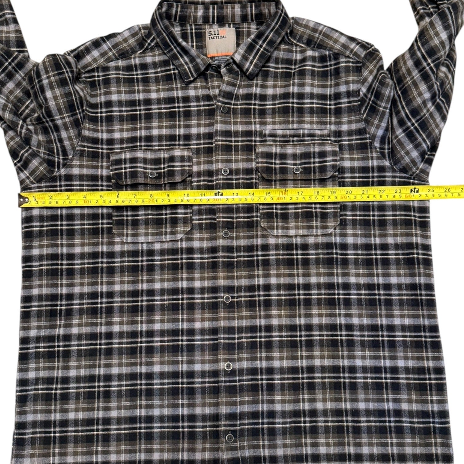 Plaid shirt with a measuring tape laid across it, showing size measurement.