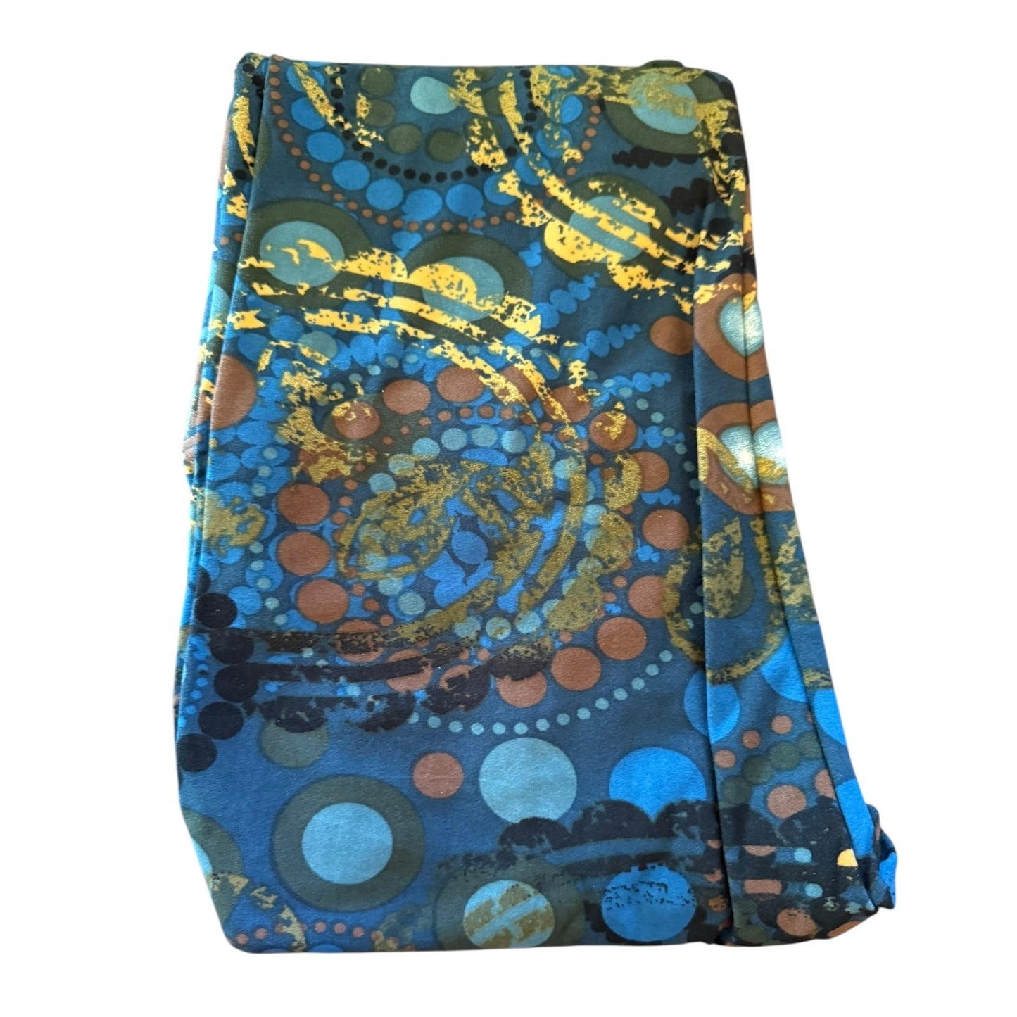 A folded leggings, featuring a vibrant abstract pattern with blue, gold, brown, and black circles and swirls on a white background.
