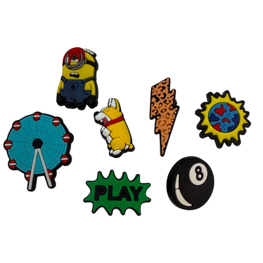 Set of colorful shoe charms featuring a minion, dog, lightning bolt, sun, Ferris wheel, 'PLAY' sign, and 8-ball on a white background.