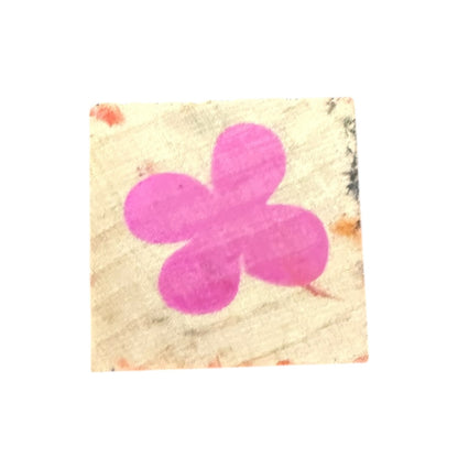 A square rubber stamp of a 4 leaf clover or flower design in the center, isolated on a white background.
