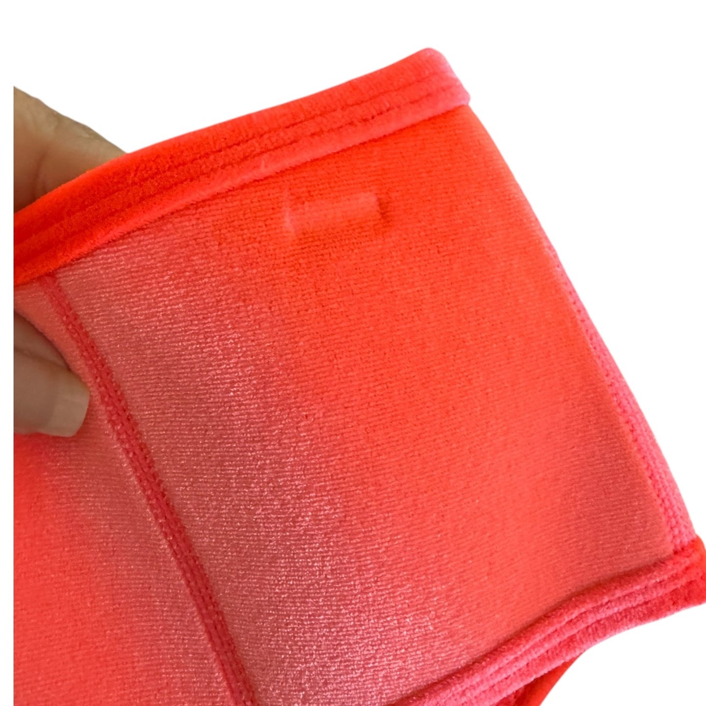 A close-up of a bright neon pink velour bikini bottom showing indention 