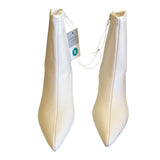 Front of a Pair of white pointed-toe shoes with a tag on a white background