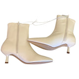 Side view of white ankle boots with a slight heel on a white background