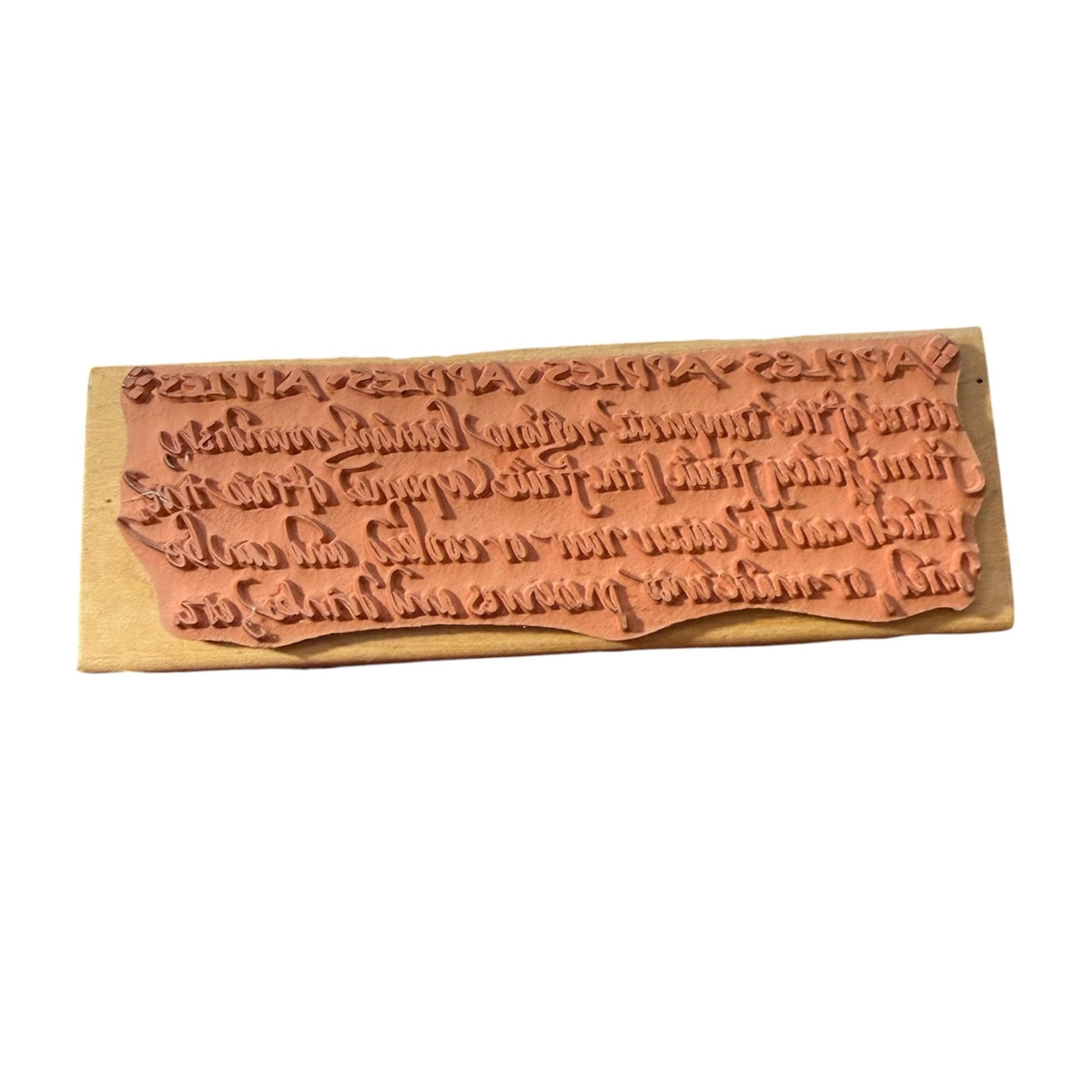 Wood stamp featuring script, mounted on a light-colored wooden base against a plain white background.