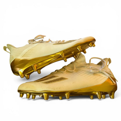 Pair of gold cleats on a white background