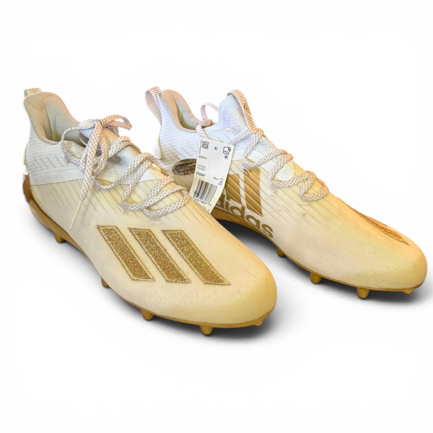 Pair of discolored soccer cleats with white laces on a white background