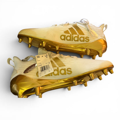 Gold Adidas football cleats with a visible tag on a white background