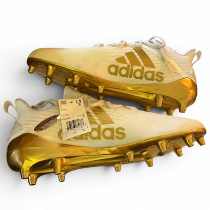 Gold Adidas football cleats with a visible tag on a white background