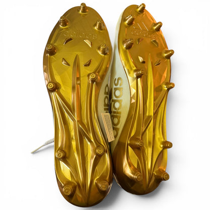 Gold Adidas soccer cleats on a white background