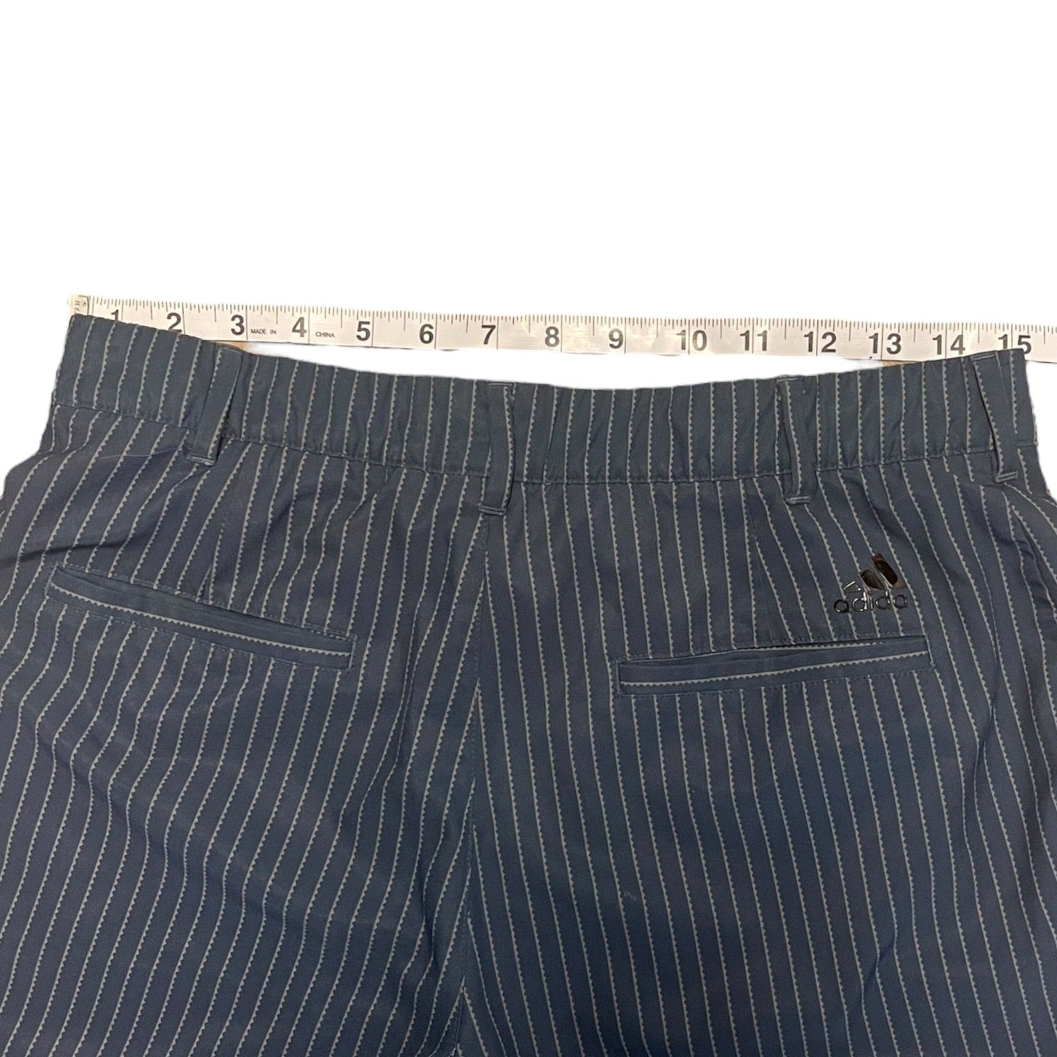 Pinstripe pants with a tape measure on a white background