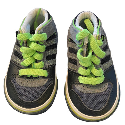 Pair of children's sneakers with green laces on a white background