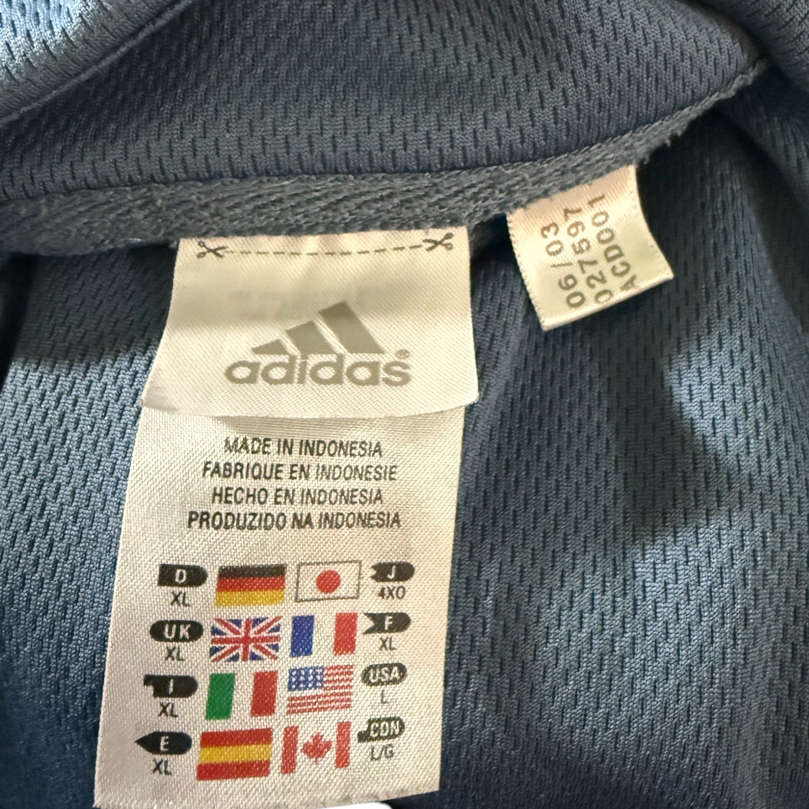 Adidas label on a sports shirt with size chart