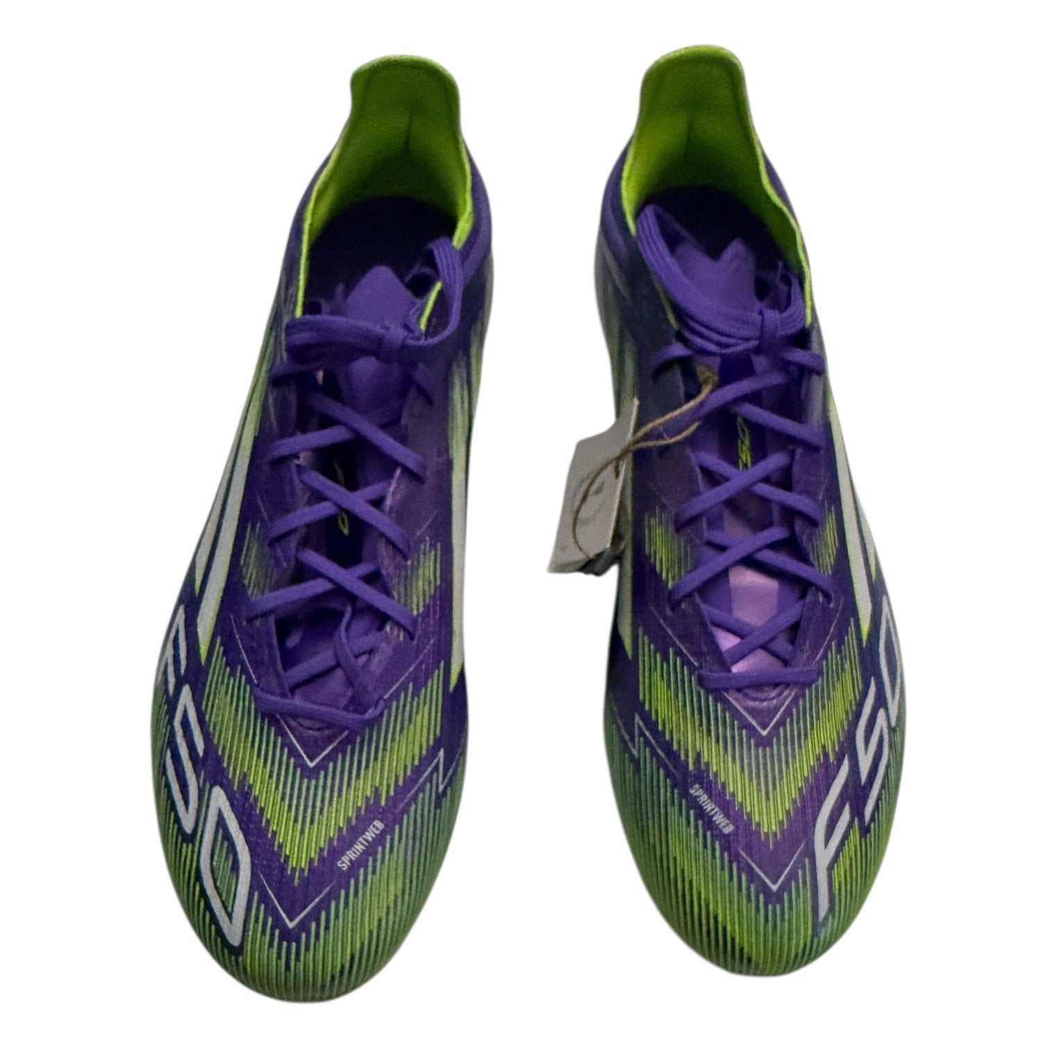 Front of Purple and green soccer cleats on a white background