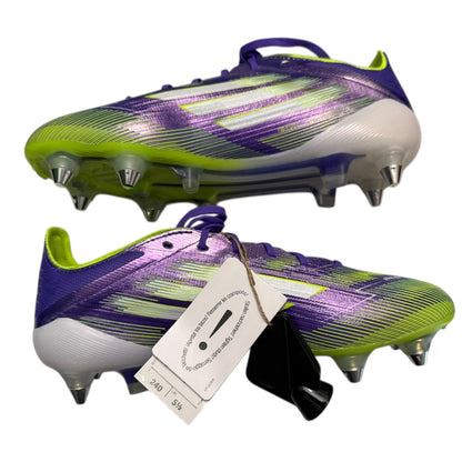 Side view of Purple and green soccer cleats with a tag on a white background